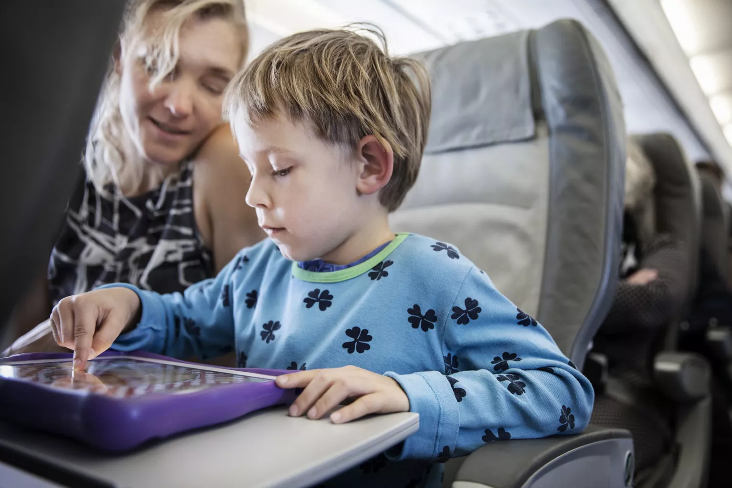 A picture of a child playing a game on an airplane