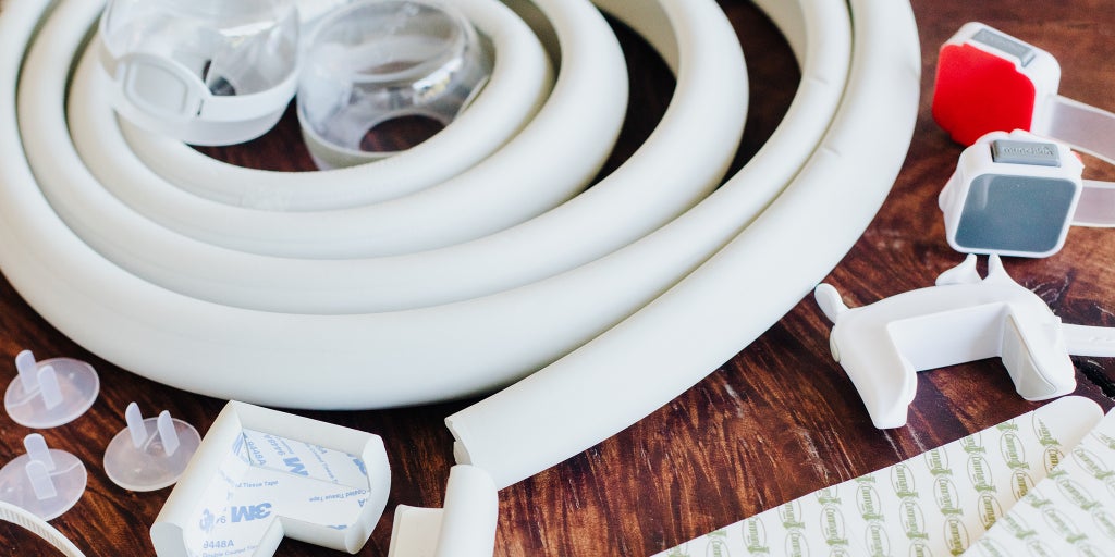 Some of our favorite baby-proofing tools strewn on a wooden table.