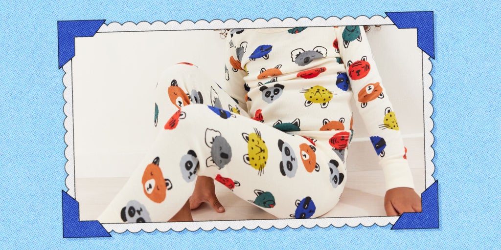 A child wearing Hanna Andersson pajamas with illustrations of different animals on them.